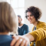 a person comforts another during a group therapy session