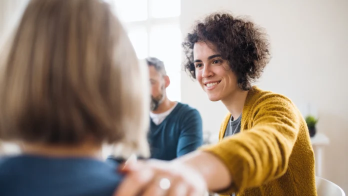 a person comforts another during a group therapy session