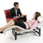 A woman in a chair speaks with a psychologist