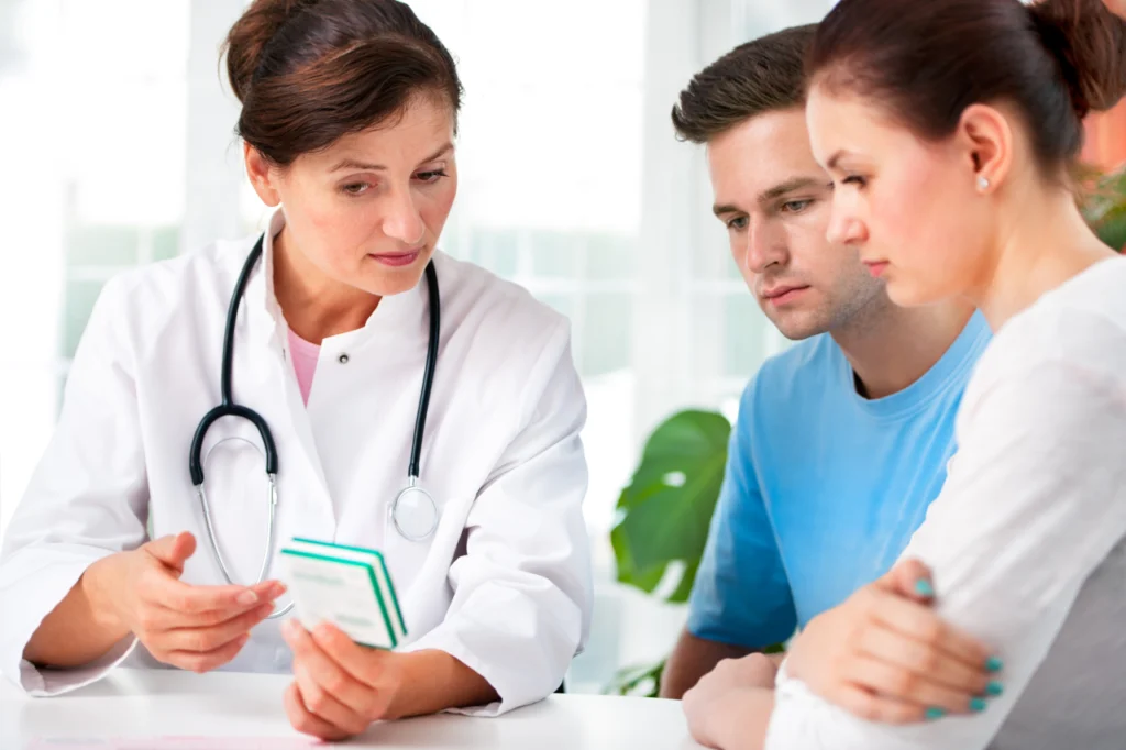 A doctor speaks with two patients at a consultation