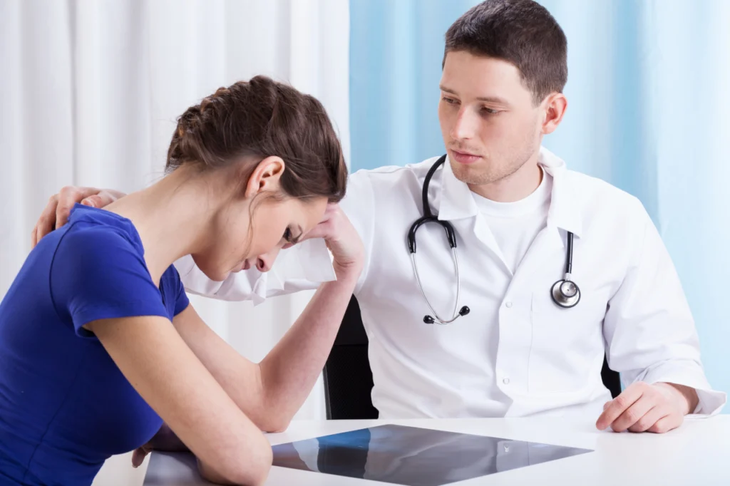 A doctor speaks with an anxious patient during a consultation