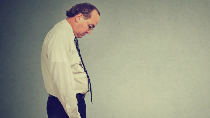 A depressed man hangs his head