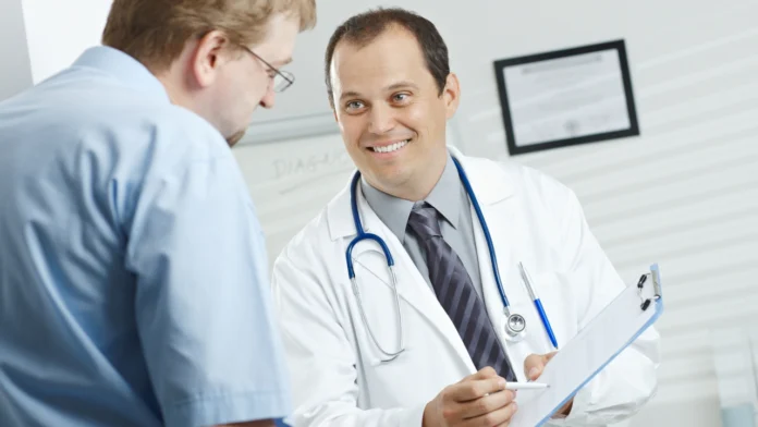 A smiling doctor speaks with a patient during a consultation