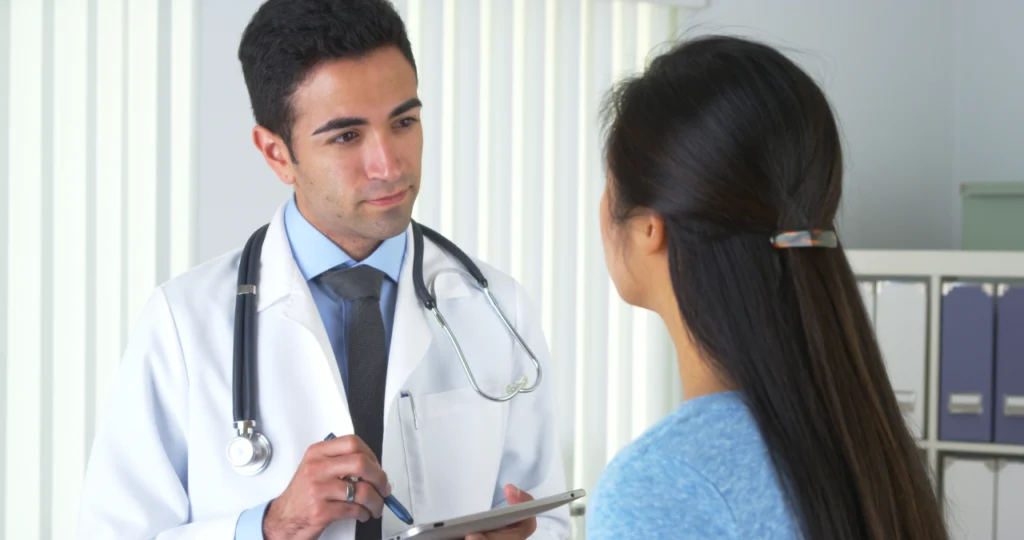 A doctor speaks with a patient during an appointment