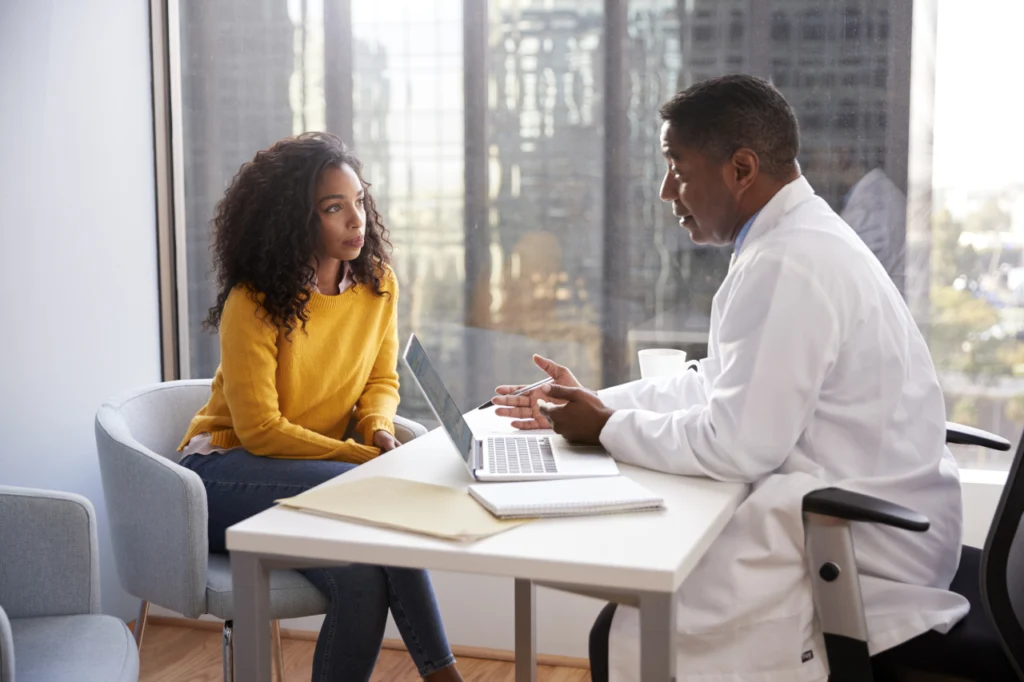 A woman speaks with her doctor during a consulation