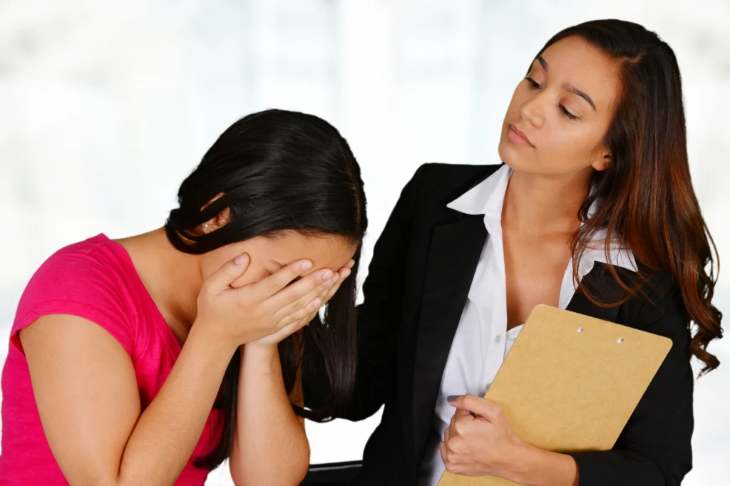 A psychiatrist comforts a patient by rubbing their shoulder