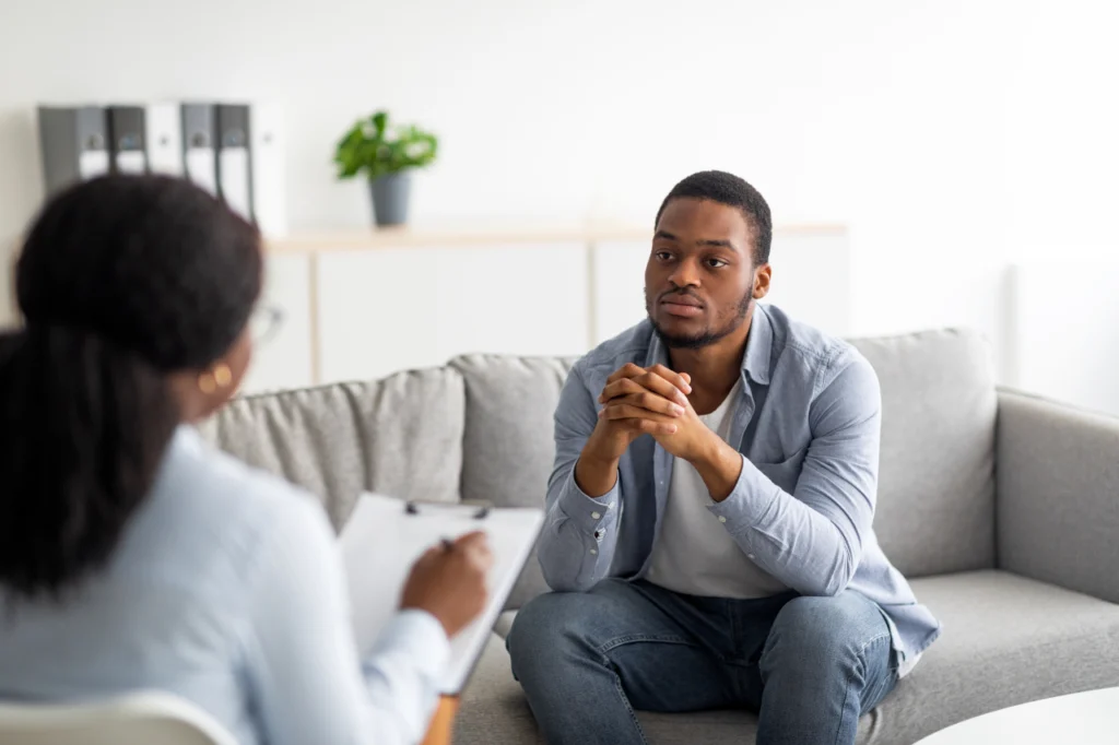 A a man in a therapists office, speaking with a therapist