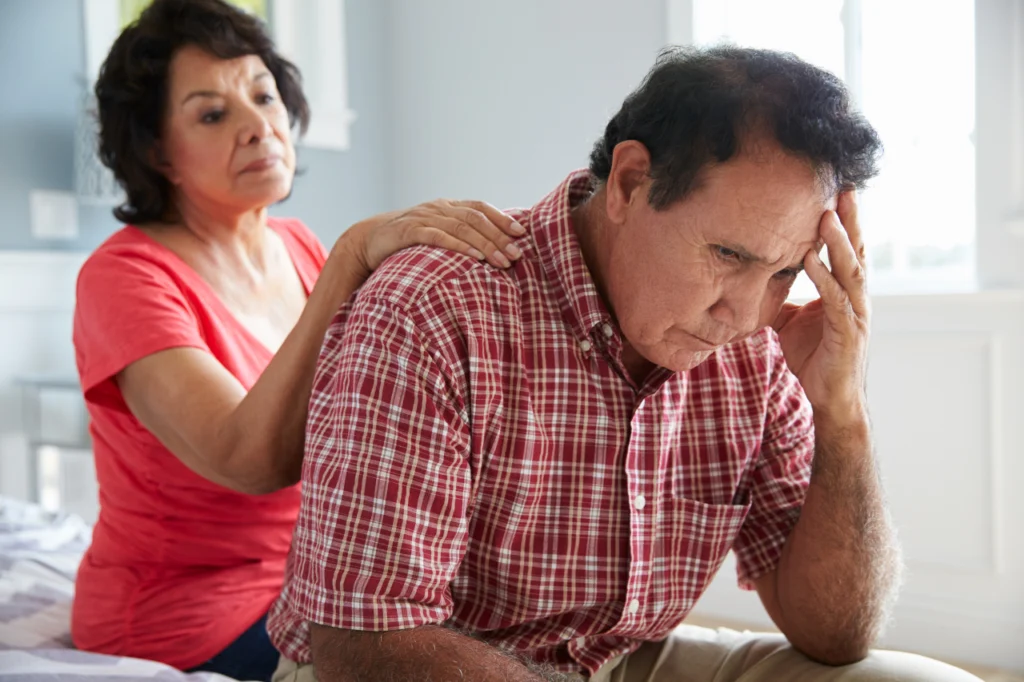 A woman comforts her husband as he deals with mental illness