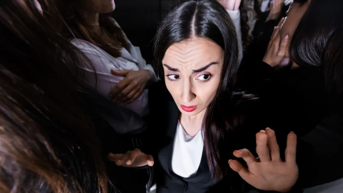 A woman starts feeling anxious in the middle of a crowd, a symptom of agoraphobia