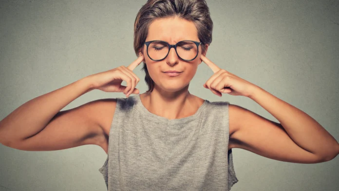 A person plugs their ears, refusing to hear critique. Learn more about passive aggression and related behaviors here.