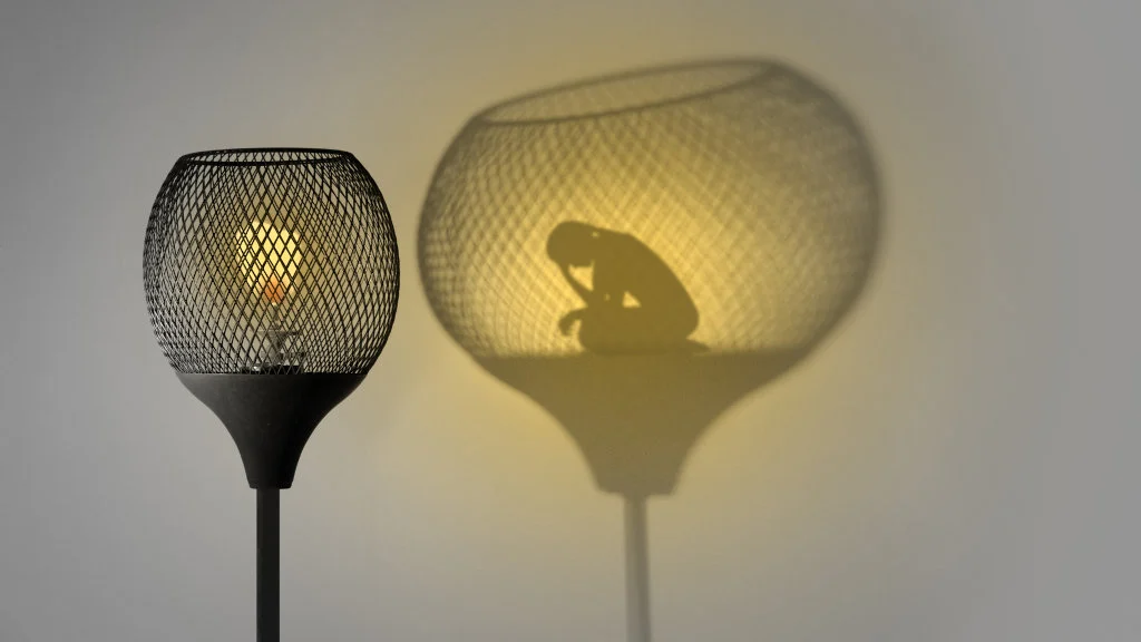 a lamp with a silhouette of a woman in it's shadow