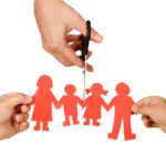 A pair of scissors separating a paper doll family, suggesting divorce