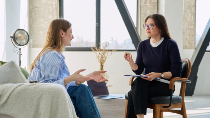 A doctor and a patient talking during an appointment. Learn more about how to find a therapist here.