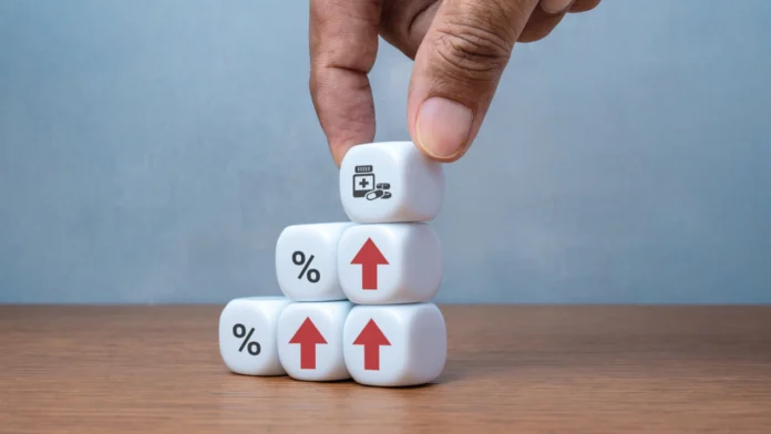 A person stacking dice together, representing the cost of medical care. Learn more about sliding scale for therapy, including 11 affordable options, here.